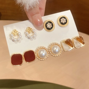 Detail showing various elegant pearl and enamel heart stud earrings in a luxury set