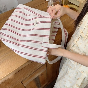 Detail of red and white striped canvas tote bag showing textured fabric and large capacity