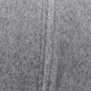 Détail de la texture en fausse fourrure grise avec fibres denses et ligne de couture