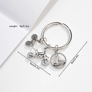 Detail of metal keychain with bicycle, motorcycle and sailboat charms on white background