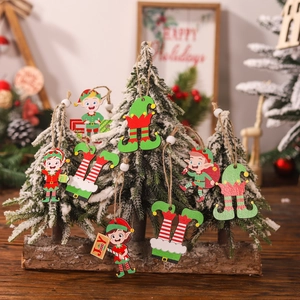 Set of 12 colorful wooden Christmas elf ornaments hanging on a small snowy festive tree