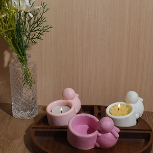 Charming bird-shaped candle holders in pink and white on a rustic wooden tray