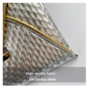 Macro shot of silver snakeskin textured fabric with sleek gold metal trim detailing