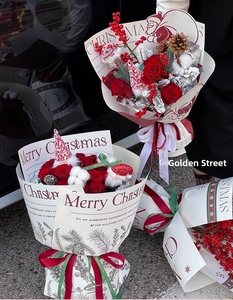 Detail of Christmas flower bouquet with red roses, pine cones, and vintage wrapping paper