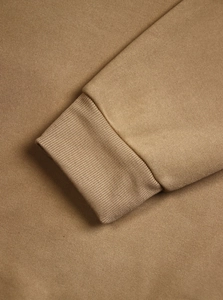 Detail of ribbed cuffs on a men's vintage half-zip sweatshirt in tan knit fabric