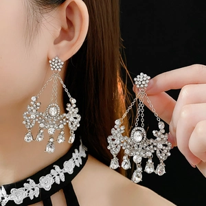 Macro detail of elegant silver drop earrings with shimmering crystals on a model
