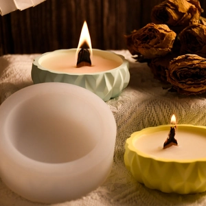 Macro detail of geometric teardrop candle silicone mold with finished wax products