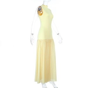 Dettaglio abito lungo giallo con scollo all'americana e orlo a pieghe in mesh a pois