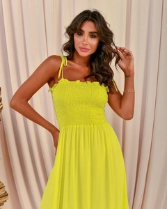 Detailed view of neon yellow smocked bodice and thin spaghetti straps on a summer dress