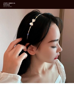 Close-up of a silver metal headband featuring heart-shaped rhinestone bow detail on a model