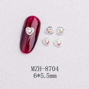 Macro detail of silver heart nail charms with AB rhinestones and size 6x5.5mm labels