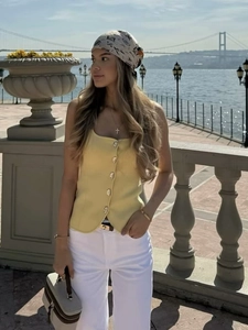 Débardeur en tricot jaune clair à boutons pour femmes avec pantalon blanc et foulard en soie