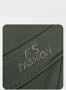 Detailed close-up of FS FASHION embroidery on olive green cotton military flat top cap
