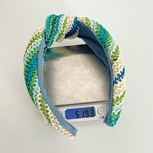 Vue détaillée du bandeau tressé avec nœud pesant 51,93 grammes sur une balance de mesure