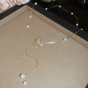 Close-up of 18k gold plated heart pendant with sparkling zircons and elegant pearls