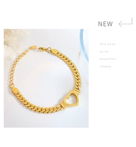 Detail of 18K gold-plated curb chain bracelet featuring a hollow heart charm and clasp