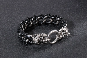 Detail of tiger head stainless steel clasps on a black braided leather punk bracelet