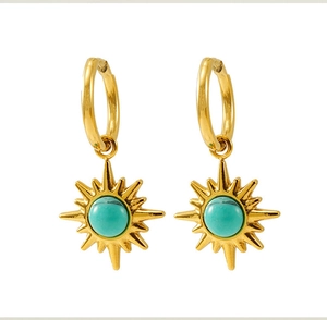 Close-up of golden sunburst drop earrings with synthetic turquoise inlay on white background