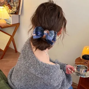Navy blue tie-dye plush bow claw clip styled in a cozy bun for an elegant daily look