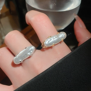 Close-up of irregular baroque pearl rings in gold and silver finish on hand