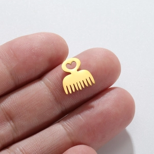 18K gold plated heart comb pendant in stainless steel shown on finger for scale