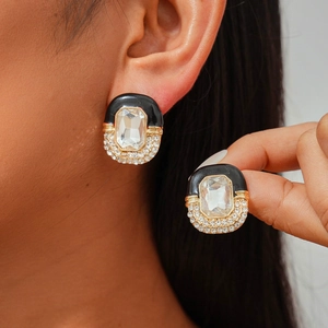 Close-up of vintage oval earring with black enamel, step-cut stone and micro-pave crystals