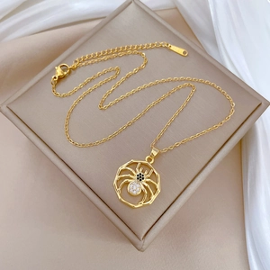 Detail of gold spider pendant necklace featuring black and clear cubic zirconia stones