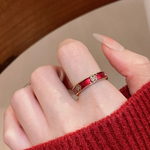Detail of red enamel 18k gold ring with tiny floral crystal accents on a model hand
