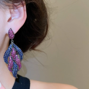Detail of luxury drop earrings with blue and rose pink cubic zirconia in retro style