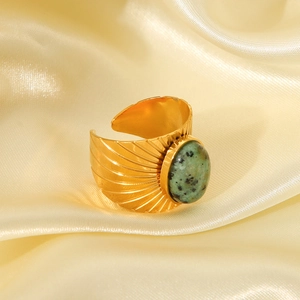 Detail of vintage gold wide ring featuring an oval green turquoise stone on silk