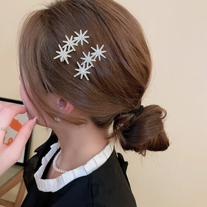Detailed view of silver star hair clips with sparkling rhinestones worn on hair