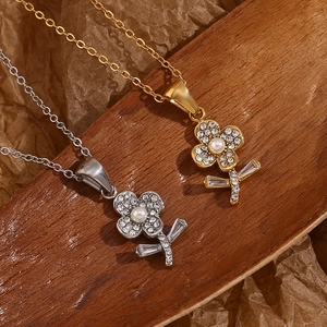 Nahaufnahme der 18K vergoldeten Blumenhalskette mit weißer Perle und Kristallen