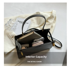 Top-down view showing internal capacity of black leather tote bag with daily essentials