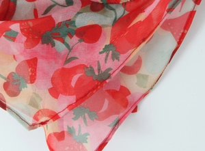 Dettaglio della stampa a fragola rossa su tessuto chiffon con fine cucitura overlock