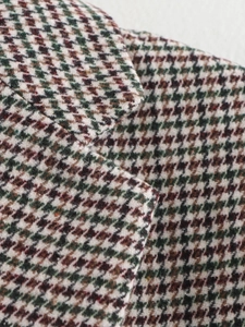 Close-up of the textured houndstooth fabric weave on a classic wool blazer lapel