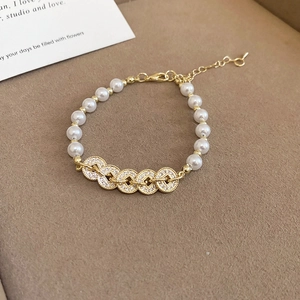 Detail of pearl bracelet with zircon inlaid gold rings and adjustable lobster clasp
