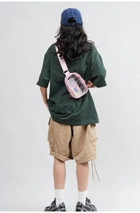 Rear view of a pink transparent PVC crossbody bag worn by a model with a green t-shirt