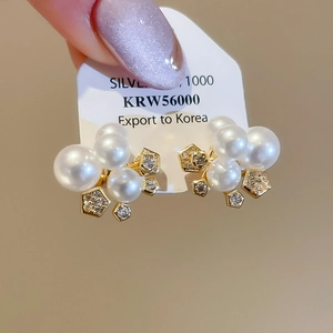 Gros plan de boucles d'oreilles fleurs élégantes avec perles blanches et zircons