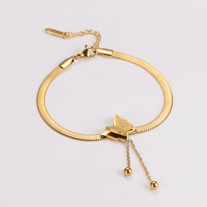 Detail view of gold butterfly tassel pendant on stainless steel snake chain bracelet