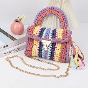 Macro shot of colorful crochet handbag with gold metal clasp and long chain strap