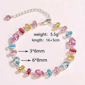 Detailed macro view of multi-color zircon stones on a silver chain bracelet with extension