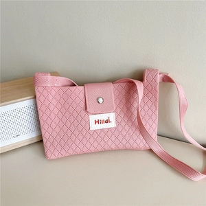 Detailed texture of pink knitted crossbody bag with diamond pattern and magnetic flap
