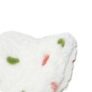 Close-up of white faux fur material with vibrant green and orange polka dots details