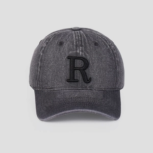 Détail d'une casquette de baseball en jean délavé avec lettre R brodée et visière courbée