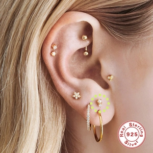 Close-up of S925 sterling silver gold stud earrings with geometric shapes and crystals