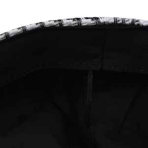Detailed macro view of the houndstooth pattern fabric and stitching on beret hat edge