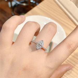 Macro shot of a luxury marquise-cut zircon ring with pavé diamonds on a model's finger