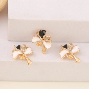 Detailed view of flower charms with gold plating, black enamel, and white cubic zirconia