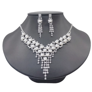Detailed view of silver bridal jewelry set with pearls and rhinestones on a black mannequin