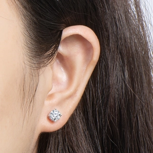 Close-up of four-prong moissanite stud earring in 925 sterling silver on a female ear